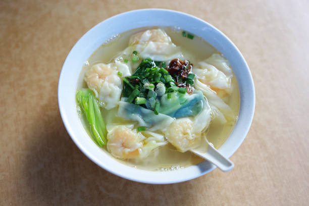 Shrimp wontons with flat noodles soup, table top view