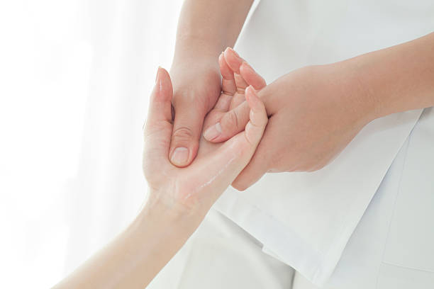 la mano de un esteticista que masajes - massaging human arm obscured face only women fotografías e imágenes de stock