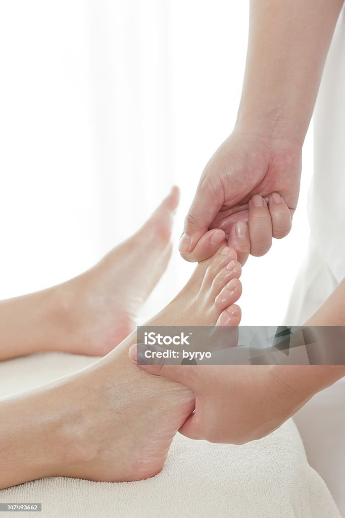 O esteticista que massagens um pé - Foto de stock de Adulto royalty-free