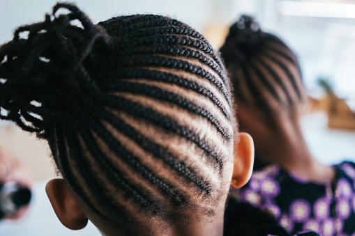 Rear view of African girl with braided hair at studio