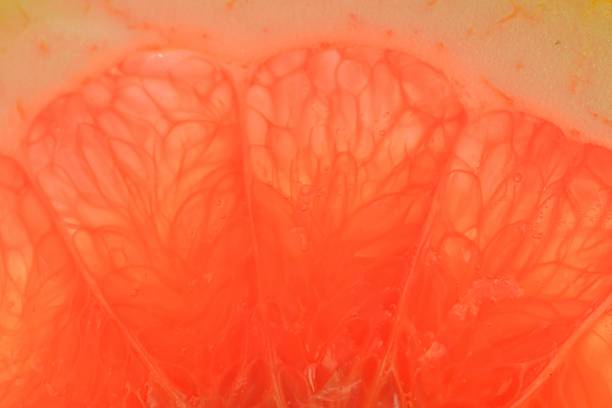 istock Grapefruit close-up. Slice of blood red ripe grapefruit. Texture of red juicy grapefruit. Macro image 1474940701