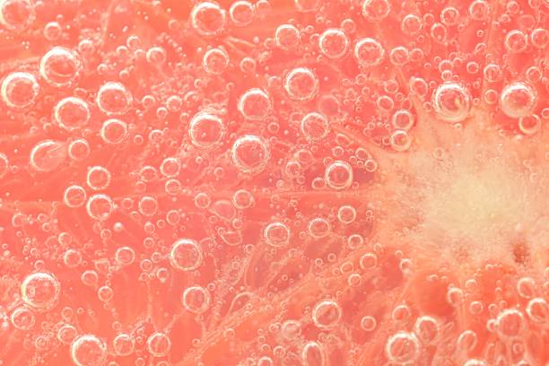 Slice of grapefruit in sparkling water. Grapefruit slice covered by bubbles in carbonated water. Grapefruit slice in water with bubbles Slice of grapefruit in sparkling water. Grapefruit slice covered by bubbles in carbonated water. Grapefruit slice in water with bubbles. carbonated juice stock pictures, royalty-free photos & images