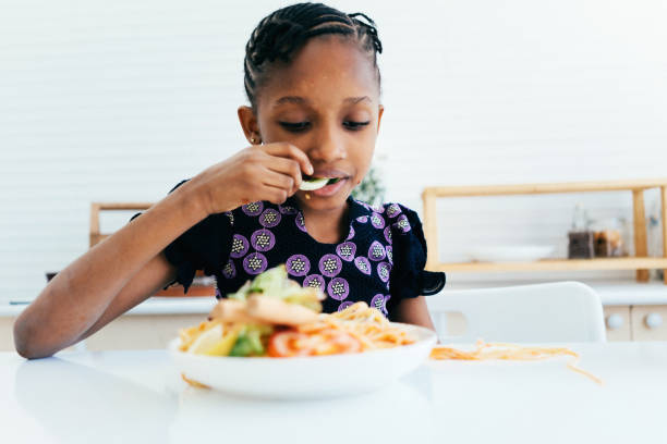 istock African American girl eating spaghetti 1474940733