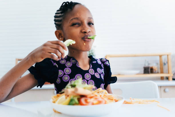 istock African girl enjoy eating spaghetti 1474940742