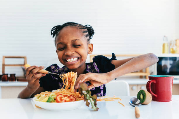 istock Hispanic girl eating spaghetti 1474940768