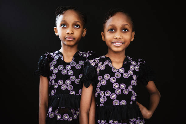 Happy family sisterly love. Two funny little twin sisters girls smiling playing together at home indoors. Happy children lifestyle. Identical twin girls. Girls friendship and youth