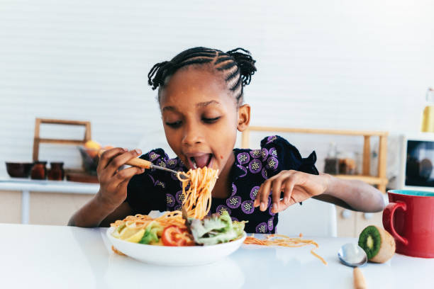 istock Hispanic girl eating spaghetti 1474940894