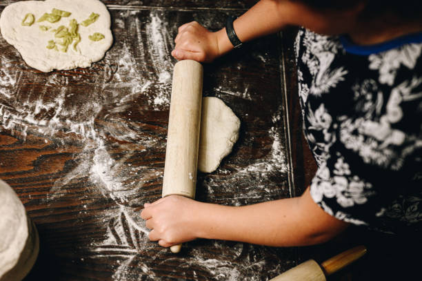 istock Family making pizza at home together at the kitchen table, hands from above 1474940942