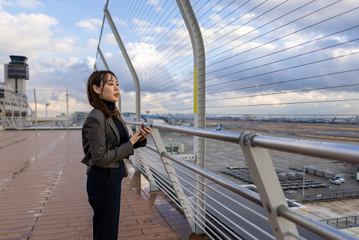 Business woman looking at view at airport observation deck