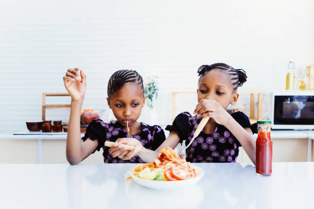 istock Twin girls enjoy eating spaghetti 1474947353