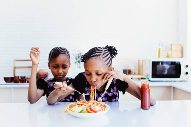istock Twin girls eating Spaghetti 1474947356