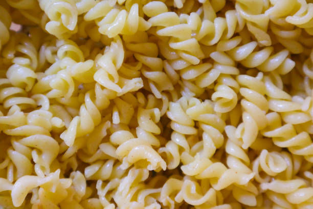 istock Fusilli spaghetti, Fusilli pasta as background image. Image texture spiral macaroni. Top view. Copy, empty space for text 1474956869