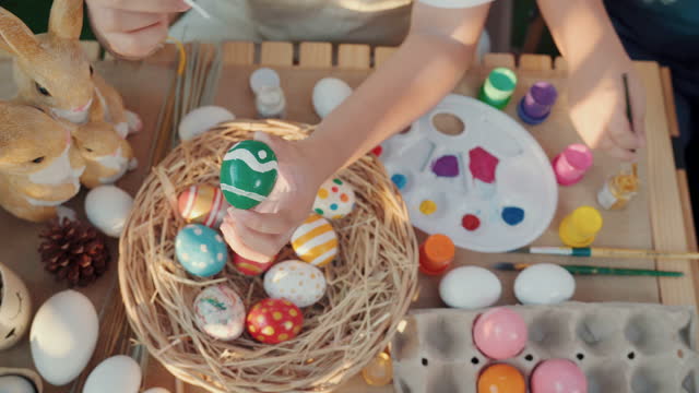 Happy Easter holiday.Close-up shot of a  child's hands painting easter eggs,Coloring eggs top view,family traditions