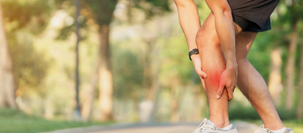 homem adulto jovem com sua dor muscular durante a corrida. homem corredor com dor nas pernas devido à tração muscular da panturrilha. lesões esportivas e conceito médico - tala - fotografias e filmes do acervo