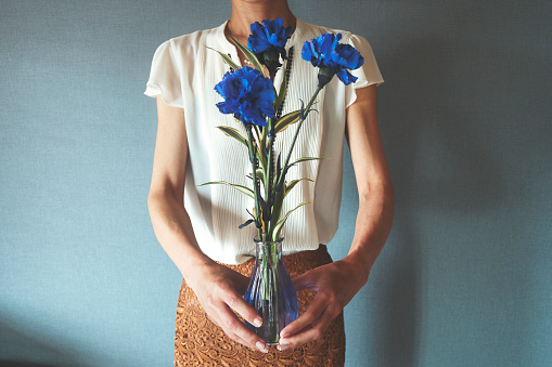 Woman with a vase of blue flowers