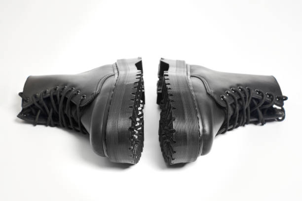 istock Black women combat boots on high heel platform with lug soles lying on isolated white background 1474967302