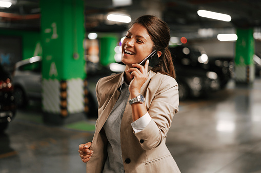 Businesswoman in suit unlocking car on parking