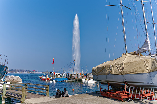 Beautiful and famous jet d'eau water fountain at Lake Geneva with rainbow at Swiss City of Geneva on a sunny winter day. Photo taken March 5th, 2023, Geneva, Switzerland.