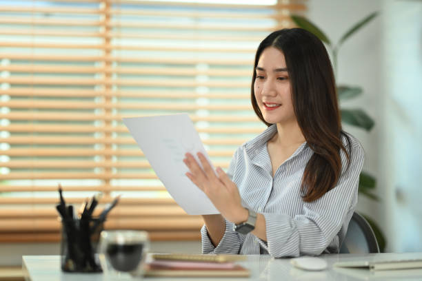 istock Smiling young female economist preparing report, analyzing work results at workplace. 1474968918