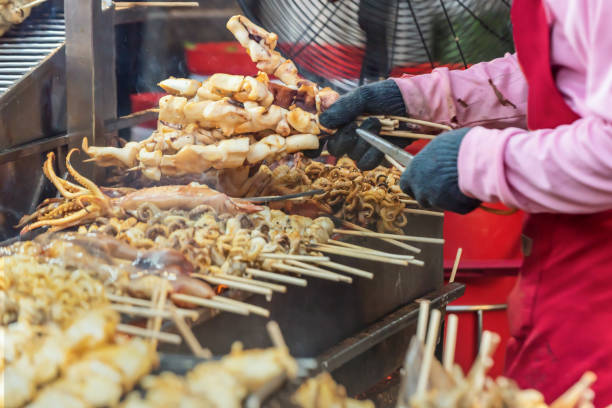 Street food options include seafood-stuffed grilled squid, unusual Asian cuisine, and charcoal-grilled squid. stock photo