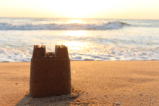 Happy kids are building sandcastle on a beach. Sunny summer evening. Majorca, Spain.\nNikon D800