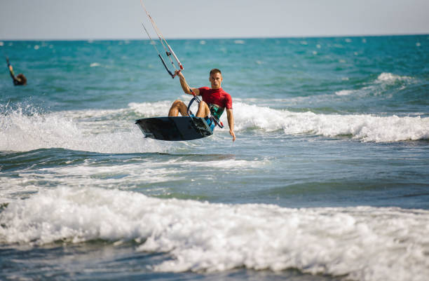 istock Young man having fun while kitesurfing on the sea. 1474973284