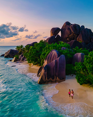 Anse Source d'Argent, La Digue Seychelles, a young couple of Caucasian men and Asian women on a tropical beach during a luxury vacation in Anse Source d'Argent, La Digue Seychelles