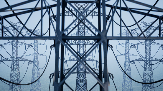A close plan of the top of the power line, metal parts of the structure connected by wires. Power lines in thick fog