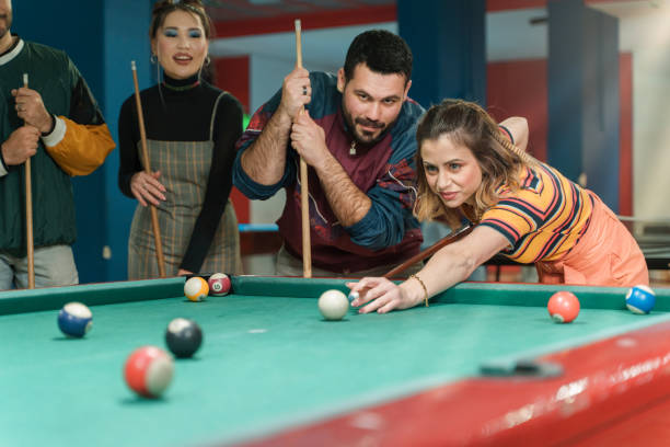 Friends having fun playing pool in arcade - Fun times with friends at the arcade stock photo