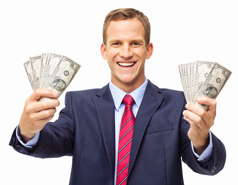 Portrait of a happy young businessman holding out handful of money. Horizontal shot. Isolated on white.