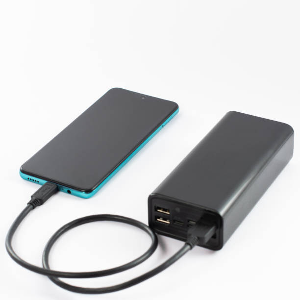 istock power bank with charging cable and phone, copy space and white background. 1474982644