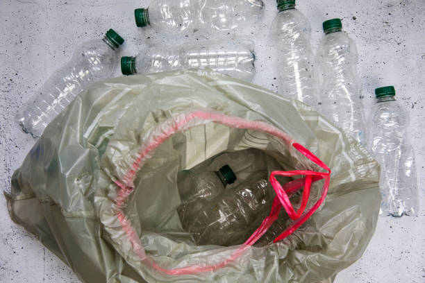 istock Recycling and ecology concept. Sorting household waste captured from above, flat lay. White concrete background empty plastic bottles 1474983222