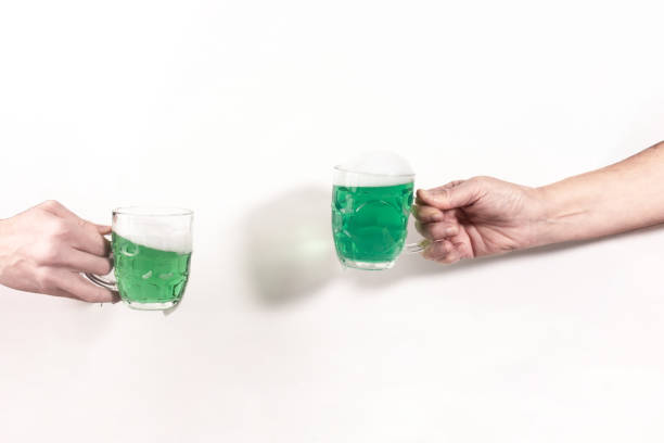 istock Cheers beer glasses with green beer on a white studio background. Saint Patrick's day 1474983572
