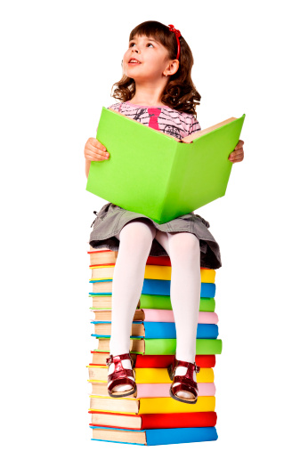 Little girl sitting on stack of books. Isolated over white
