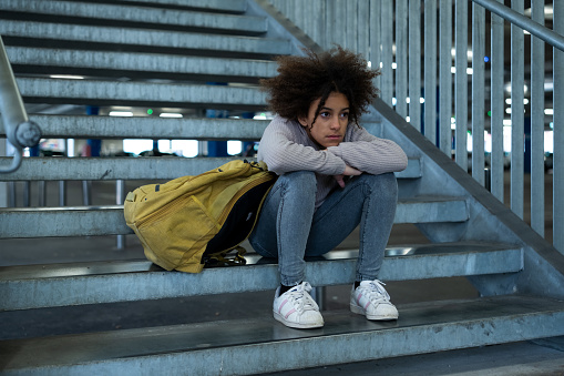 Sad girl sitting on stairs