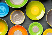 Color ceramic plates on gray background top view