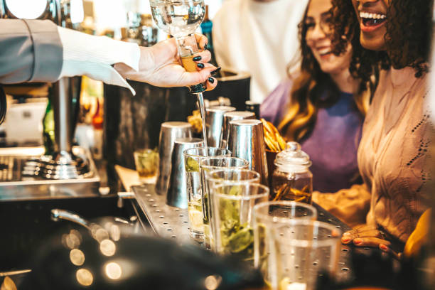 barman derramando álcool da garrafa para os copos - grupo de amigos felizes saindo na noite de fim de semana no local do bar de coquetéis - conceito de estilo de vida com barman fazendo bebidas e servindo os clientes - party nightclub night toast - fotografias e filmes do acervo