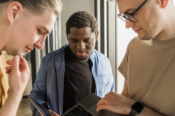 istock A young developer gives new project tasks to his partners. Business people are discussing a new business project in the office. Coding technologies, site design. Successful diverse Teamwork 1474991706