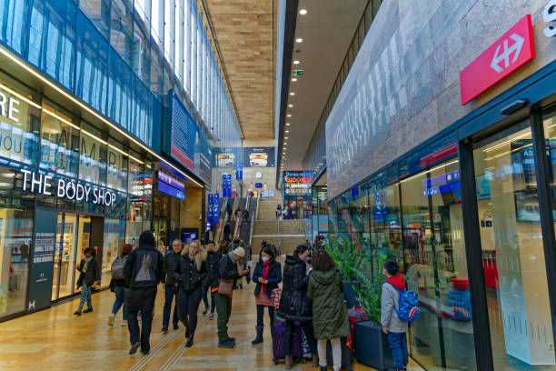 Hall of Geneva railway station Cornavin with passengers and shops on a sunny winter day. Photo taken March 5th, 2023, Geneva, Switzerland.