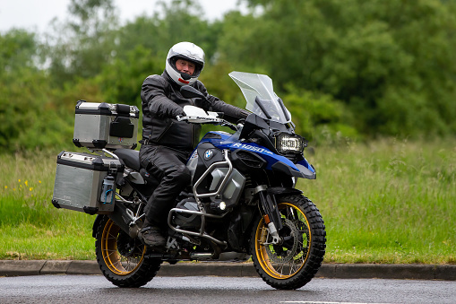 Stony Stratford, Bucks, UK - June 5th 2022. Man riding a BMW R1250 motorcycle on an English country road