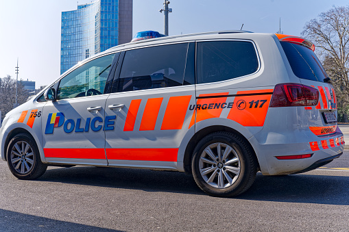 Side view of parked police car at town square named Nations at Swiss City of Geneva on a sunny late winter day. Photo taken March 5th, 2023, Geneva, Switzerland.