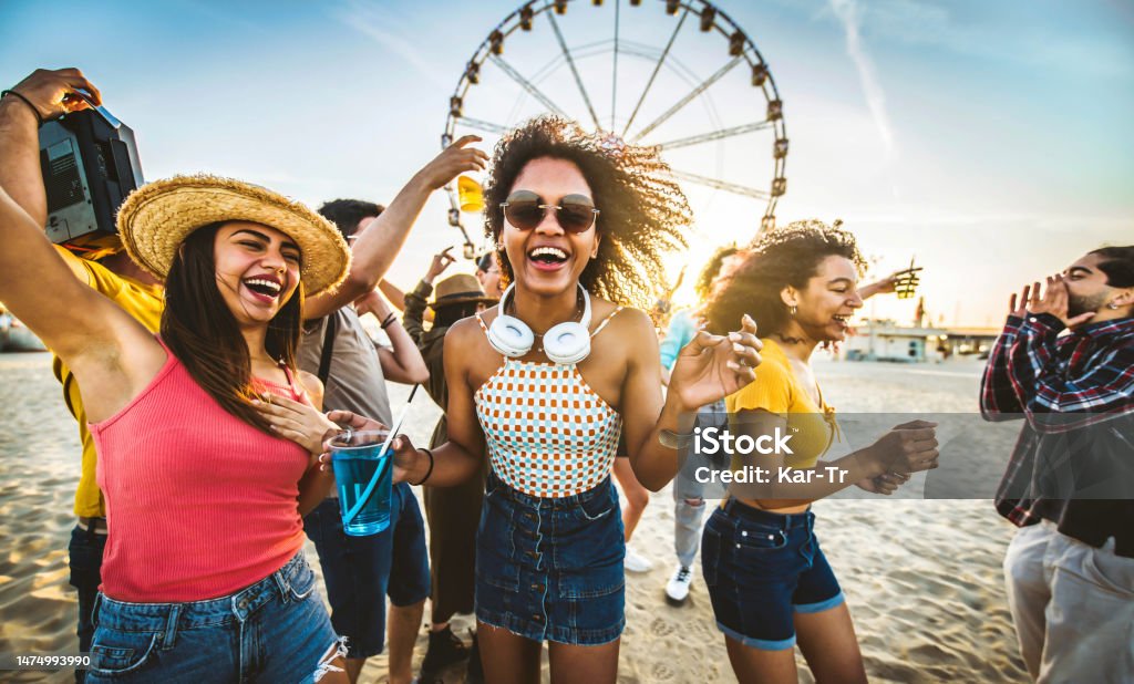 Multiracial group of friends having fun dancing at sunset beach party - Happy young people enjoying music festival on weekend vacation - Life style concept with guys and girls enjoying summer vacation Miami Stock Photo