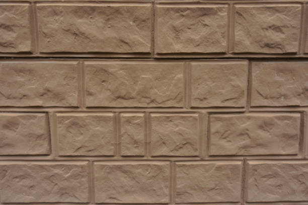 istock Close up of light brown painted brick veneer wall 1474994812