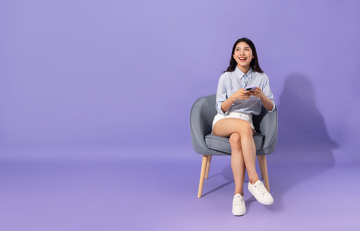 image of girl sitting on sofa  isolated on purple background