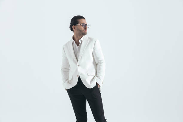 sexy élégant homme en costume veste blanche tenant les mains dans les poches et regardant sur le côté - pocket suit glasses jacket photos et images de collection