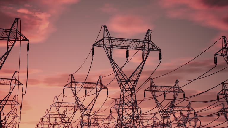 A drone flying around rows of power lines in the rays of the setting sun