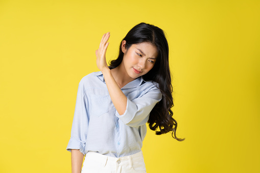 portrait of beautiful asian girl posing on yellow background