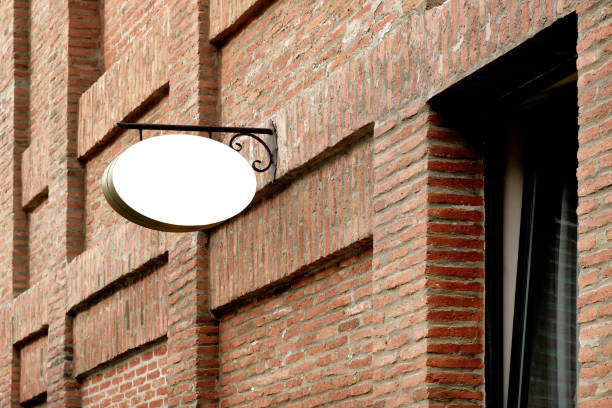 Close-up outdoor oval advertising sign on a brick wall. Template for design.