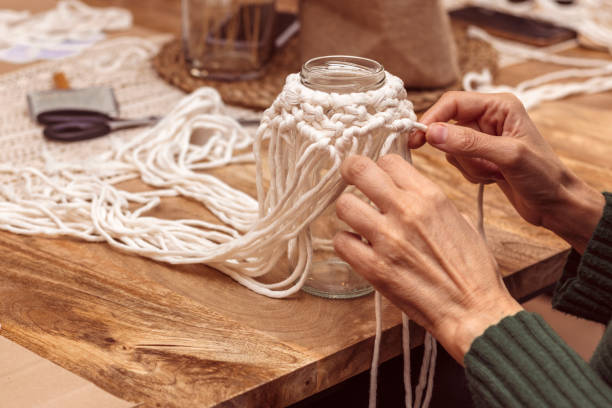 istock White macrame. Middle-aged woman weaving with macrame. 1475001828