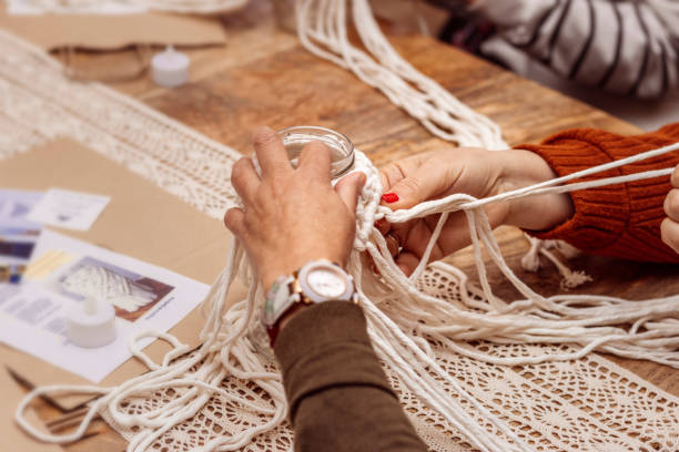 istock White macrame. Teacher and student work together on the art of macrame. 1475001845